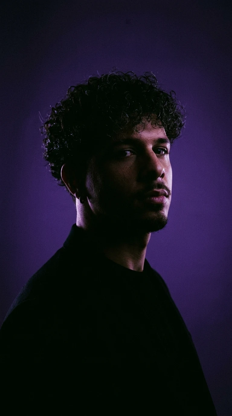 Marco Merlina di tre quarti, volto in penombra contro un fondale viola